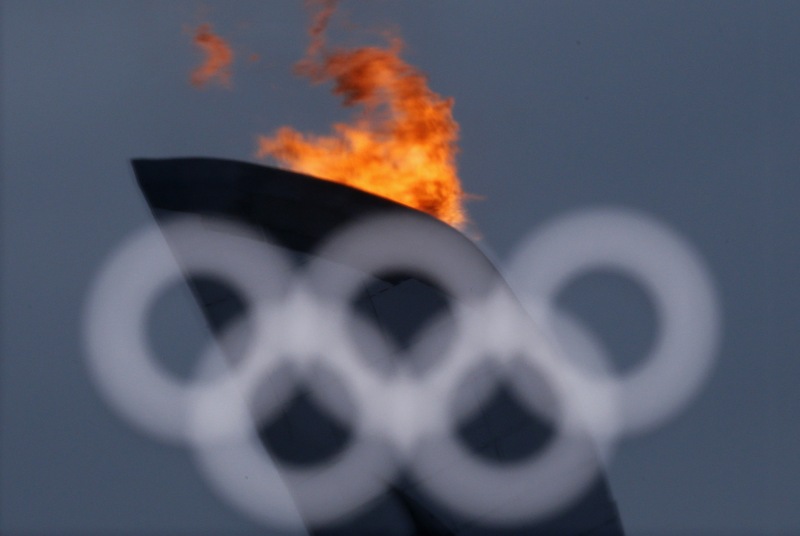 The Olympic flame is reflected in a window at the Olympics Park during the Sochi 2014 Winter Olympics